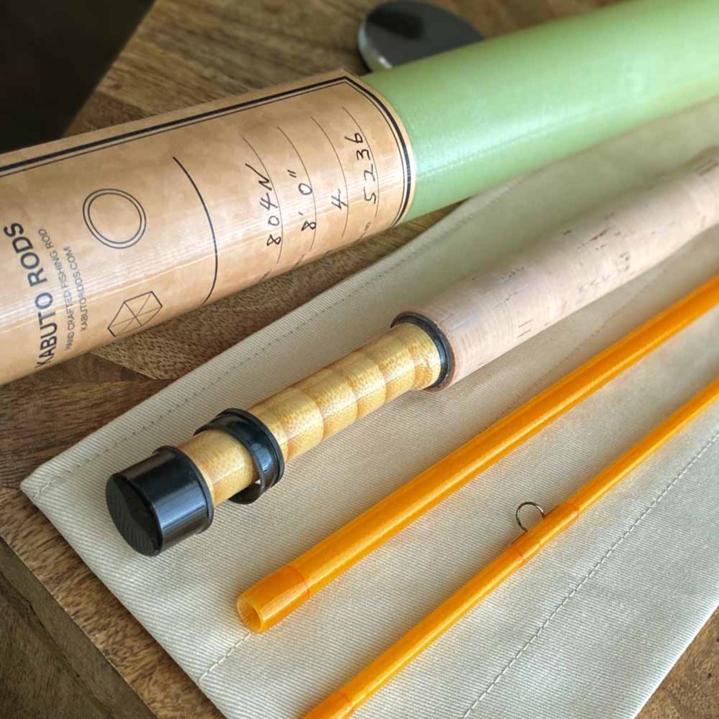 A precision-crafted yellow fly rod, 8 feet in length, designed for expert anglers. The rod features a stacked bamboo reel seat, adding a classic touch to its fiberglass construction. Its moderate action and light power offer smooth casting for fly fishing enthusiasts.