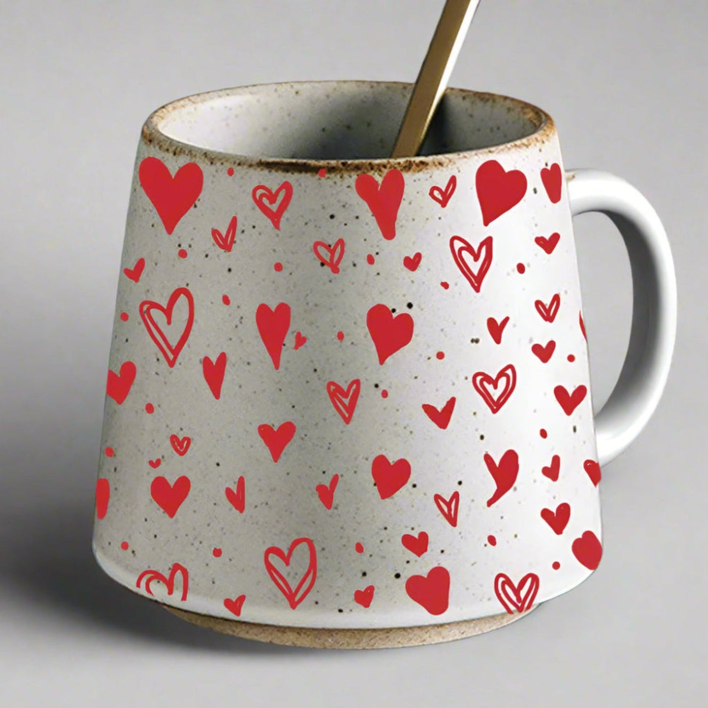 White mug with red heart pattern on a gray background