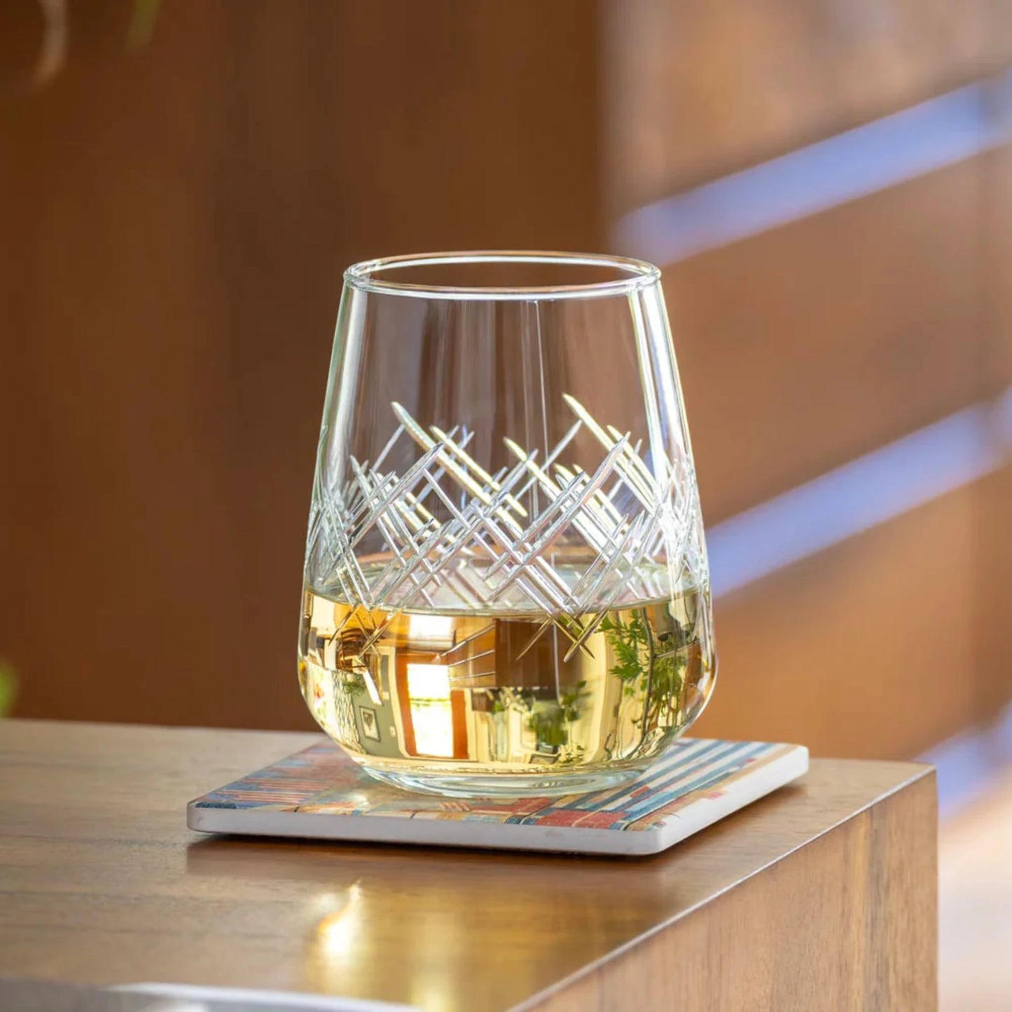 Experience the elegance of the Argyle 15.75oz Stemless Wine Glass, a timeless design inspired by the tartans of the Clan Cambell of Argyll, Scotland in the 17th century. This classic diamond pattern became an iconic symbol of British fashion after the Duke of Windsor adopted it in the 1920s. Crafted by Rolf Glass, each piece is a testament to the enduring appeal of the Argyle pattern. Elevate your wine tasting experience with this sophisticated and stylish wine glass.