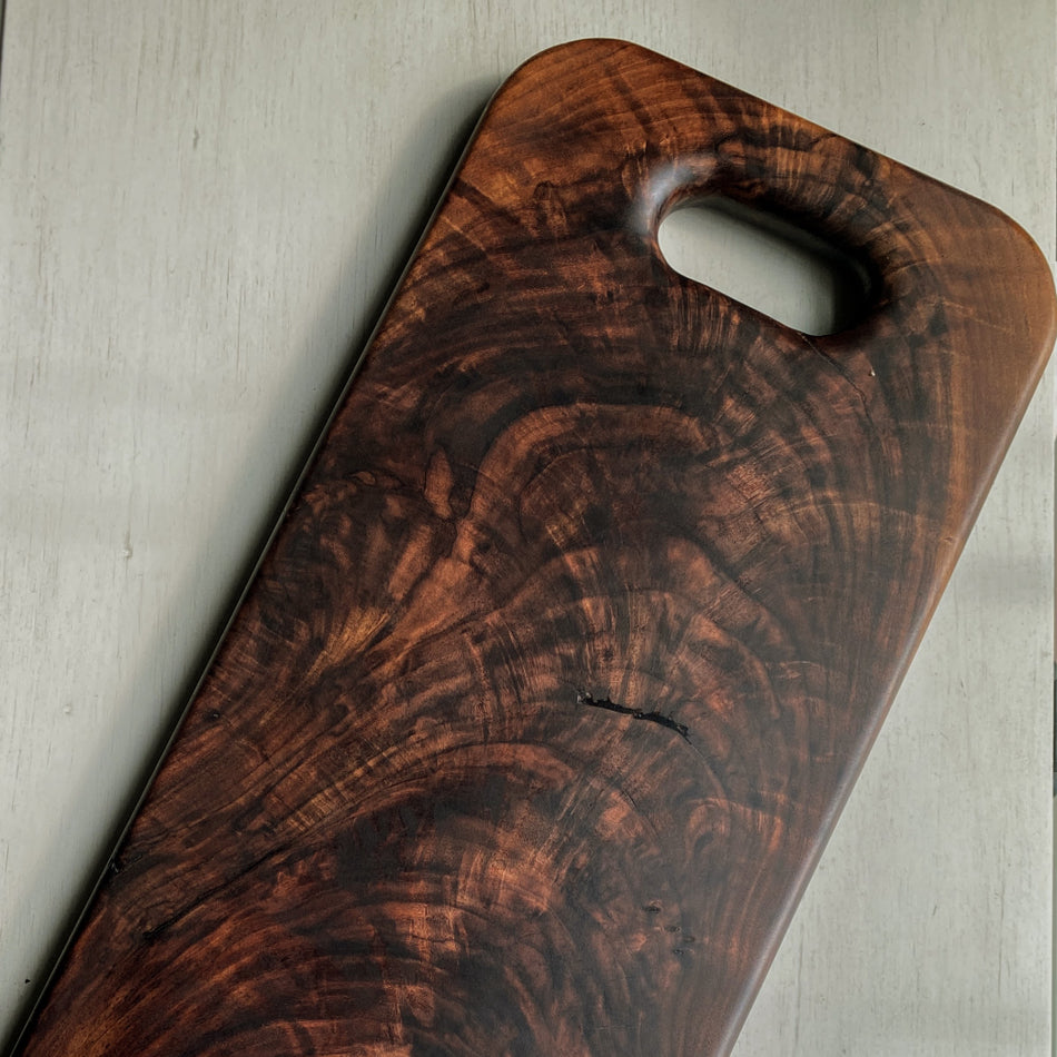 This Handcrafted Charcuterie Board is fashioned from Highly Figured Walnut wood from the Northeastern States. Its generously sized design, measuring 22
