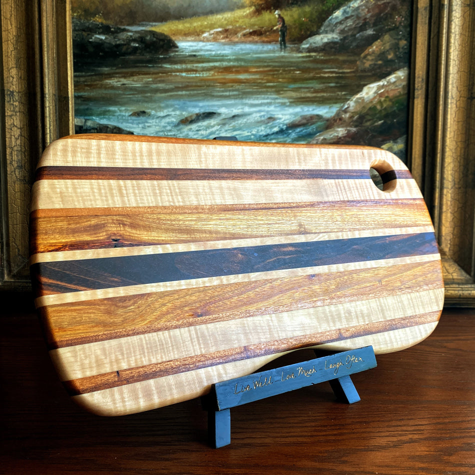 This charcuterie board is crafted with three types of wood: Carnary, Tiger Maple, and Goncalo Alves. It makes a stylish presentation for last-minute gatherings and has been expertly seasoned. It is sealed with Sutherland Welles Ltd.® Millie's All-Purpose Penetrating Tung Oil.