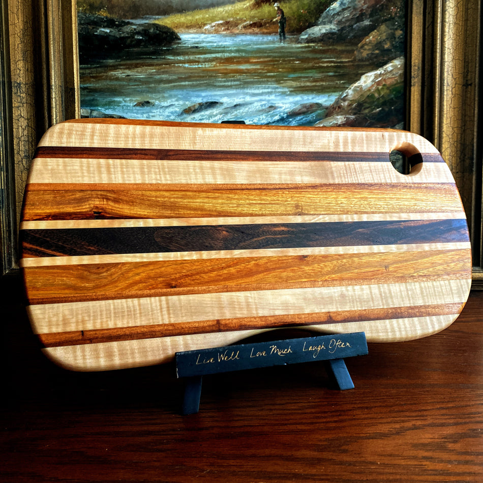 This charcuterie board is crafted with three types of wood: Carnary, Tiger Maple, and Goncalo Alves. It makes a stylish presentation for last-minute gatherings and has been expertly seasoned. It is sealed with Sutherland Welles Ltd.® Millie's All-Purpose Penetrating Tung Oil.