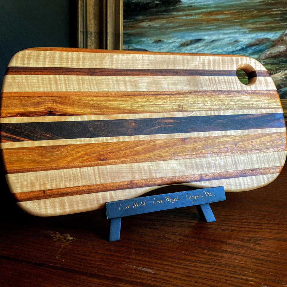 This charcuterie board is crafted with three types of wood: Carnary, Tiger Maple, and Goncalo Alves. It makes a stylish presentation for last-minute gatherings and has been expertly seasoned. It is sealed with Sutherland Welles Ltd.® Millie's All-Purpose Penetrating Tung Oil.