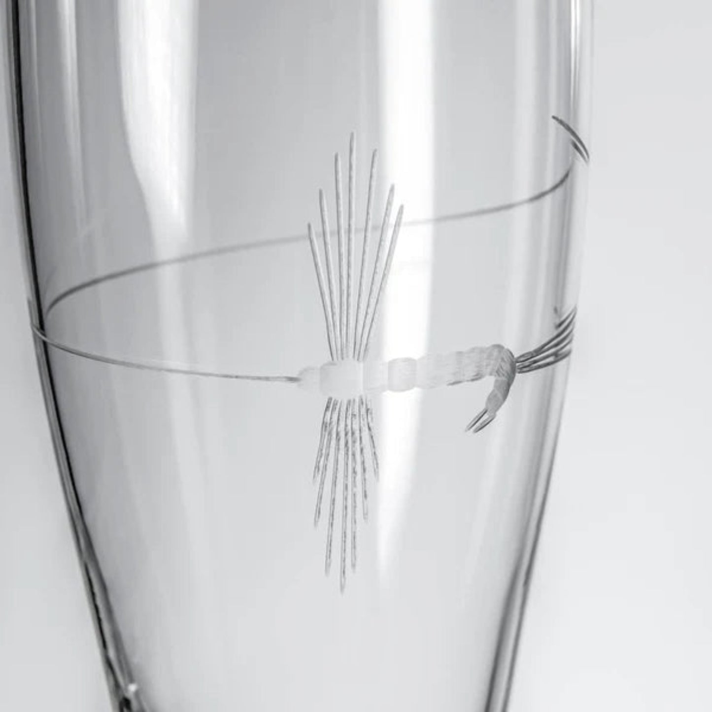 Experience the thrill of fly-fishing with our Fly Fishing 16oz Beer Pilsner. This beautifully crafted glass features a delicate lure looping around it, creating a captivating visual effect. The diamond-wheel engraving by renowned artist Phil Hopfe adds a touch of elegance. Whether you're an avid angler or a nature enthusiast, this glass is perfect for sipping your favorite brew while sharing tales of your adventures. Its sturdy base and comfortable grip make it a versatile companion for both indoor gatherin