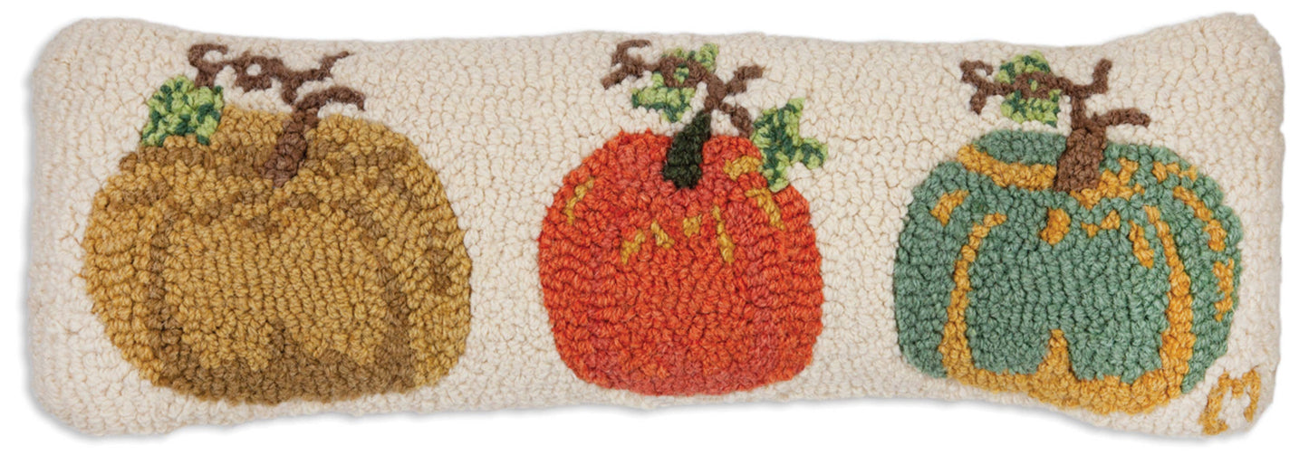 Decorative pillow with three pumpkins made from fabric on a beige background
