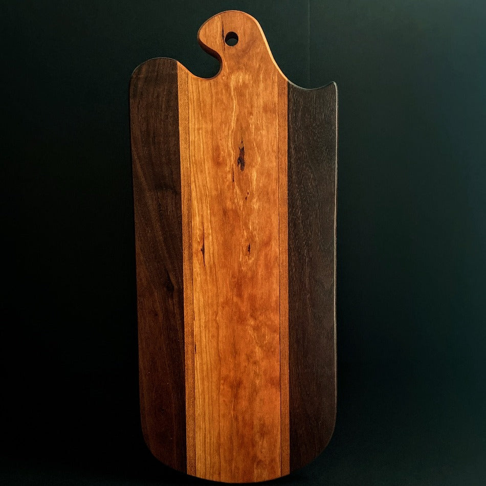 
                      
                        The Handcrafted Charcuterie Board is crafted from Gummy Cherry, Cherry and Walnut measuring 18 x 8 x 1. This combination of woods offers remarkable depth. It is then seasoned with Milie's Tung Oil.
                      
                    