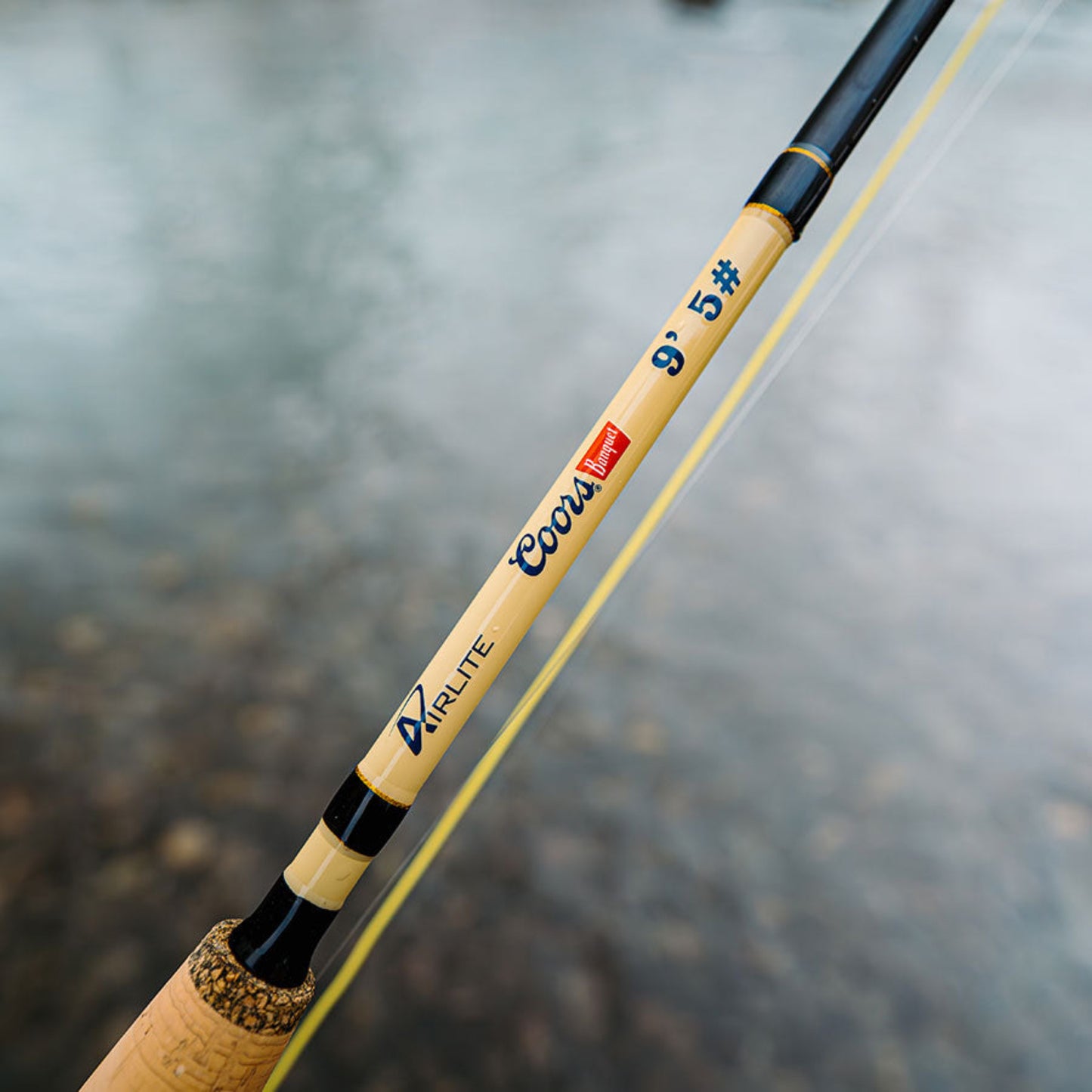 Fishing rod with cork handle and brand names on a blurred background