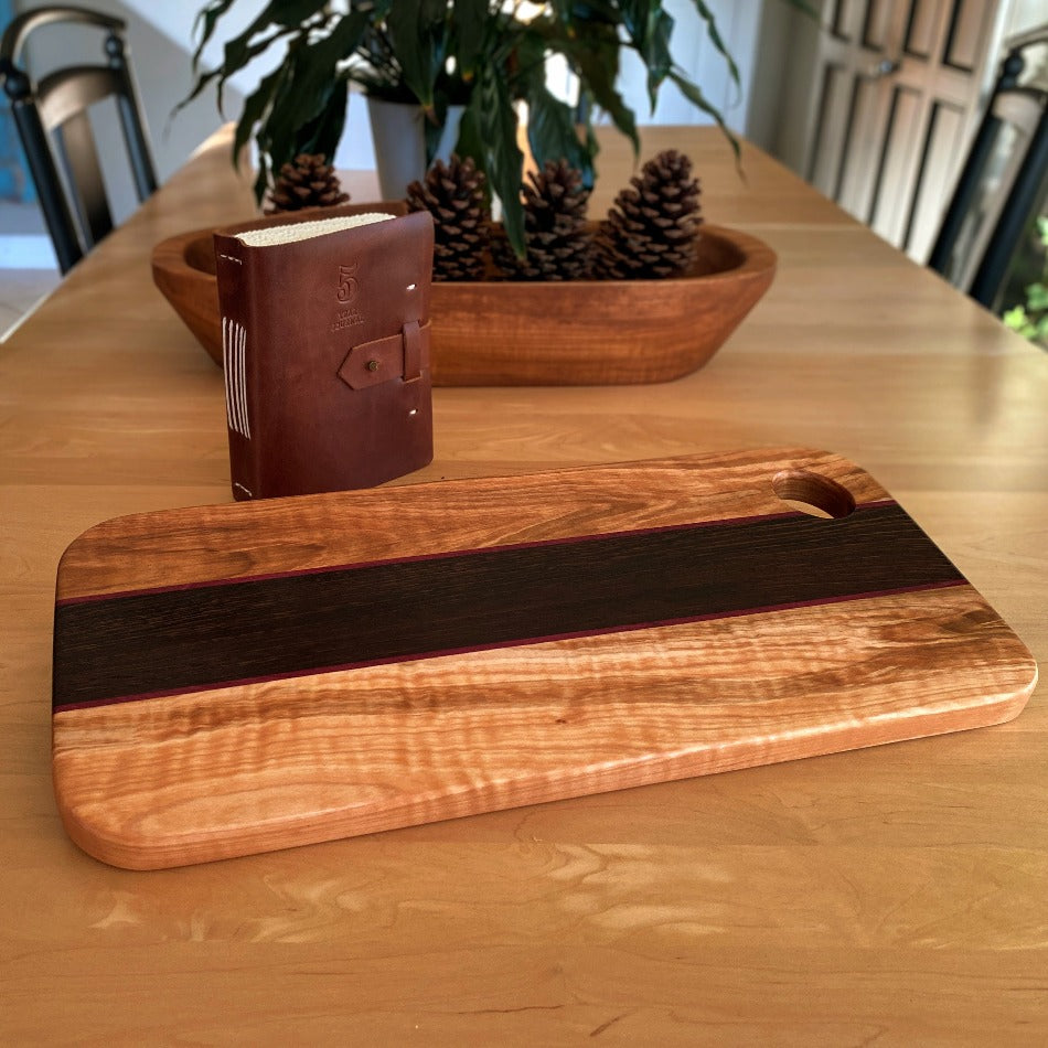 
                  
                    This eye-catching Charcuterie Board crafted from Tiger Heart Curly Maple, Purple Heart and Wenge adds a stylish touch to every tabletop. Make a lasting impression on your colleagues at the next get-together with this elegant serving board
                  
                