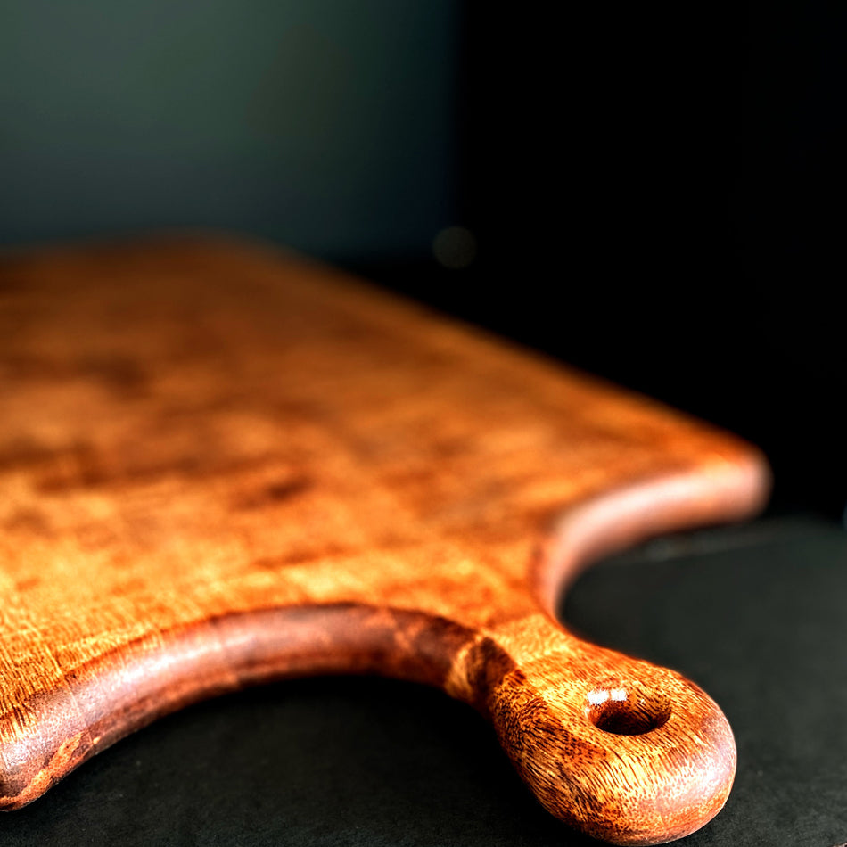 
                      
                        This Board was crafted from Curly Mango and displays a live edge with intricate detailing to retain its character and luster. The Curly Mango's captivating colors are awe-inspiring and abundant surface area to create an incredible charcuterie board.
                      
                    