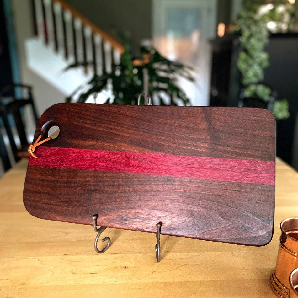 
                  
                    This handcrafted charcuterie board is the perfect way to impress guests. It's made with walnut and purple heart wood to create a stunning contrast of colors, which adds a simple, yet elegant touch to any presentation.
                  
                