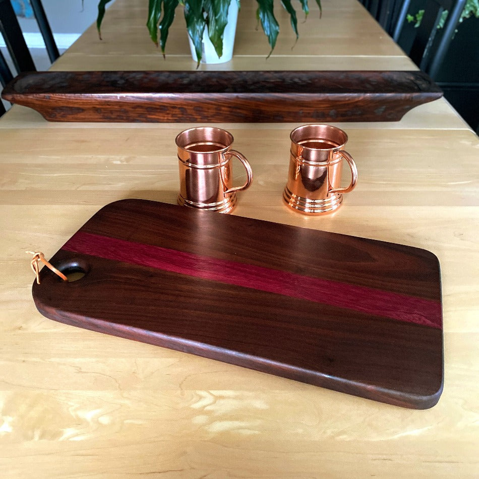 
                  
                    This handcrafted charcuterie board is the perfect way to impress guests. It's made with walnut and purple heart wood to create a stunning contrast of colors, which adds a simple, yet elegant touch to any presentation.
                  
                
