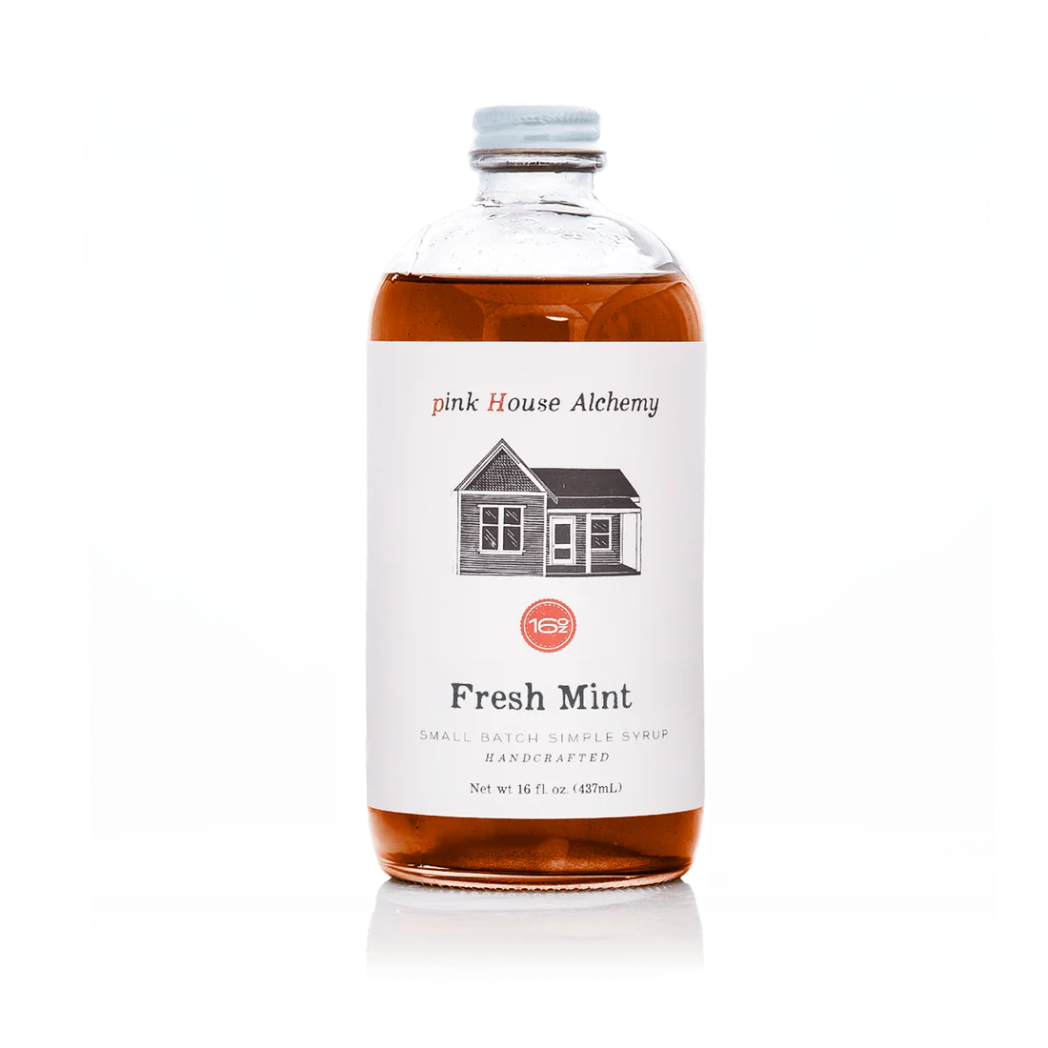 A bottle of pink House Alchemy Fresh Mint simple syrup with amber liquid inside, a white label with a house illustration, and a silver cap, shown on a white background.
