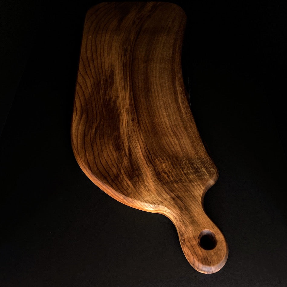 This handcrafted Charcuterie Board was crafted with gorgeous Myrtle wood. This particular piece is live edge and has amazing colors with curling towards the handle. Ideal for intimate social gatherings.  It is not recommended as a cutting board 