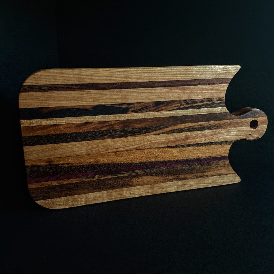 
                  
                    Simple and beautiful. This edge grain serving board is just that. Amazing Curly Cherry, Walnut, Tiger Heart Maple and Eastern Highly Figured Walnut resonates with family gatherings all year round, particularly this time of the year.
                  
                