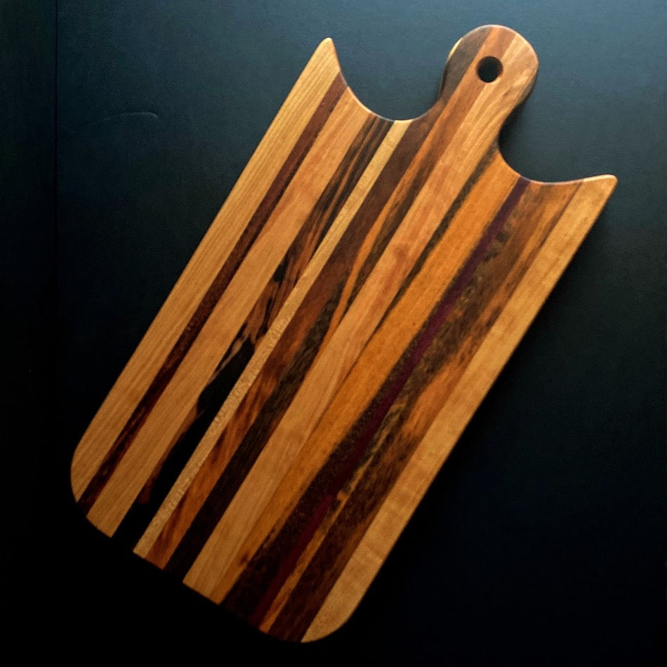 
                  
                    This simple yet beautiful Edge Grain Serving Board is made of stunning Cherry, Purple Heart, and Goncalo Alves wood. It is finished with Sutherland Welles Millie's All-Purpose Penetrating Tung Oil to enhance its natural beauty. Perfect for serving your favorite dishes.
                  
                