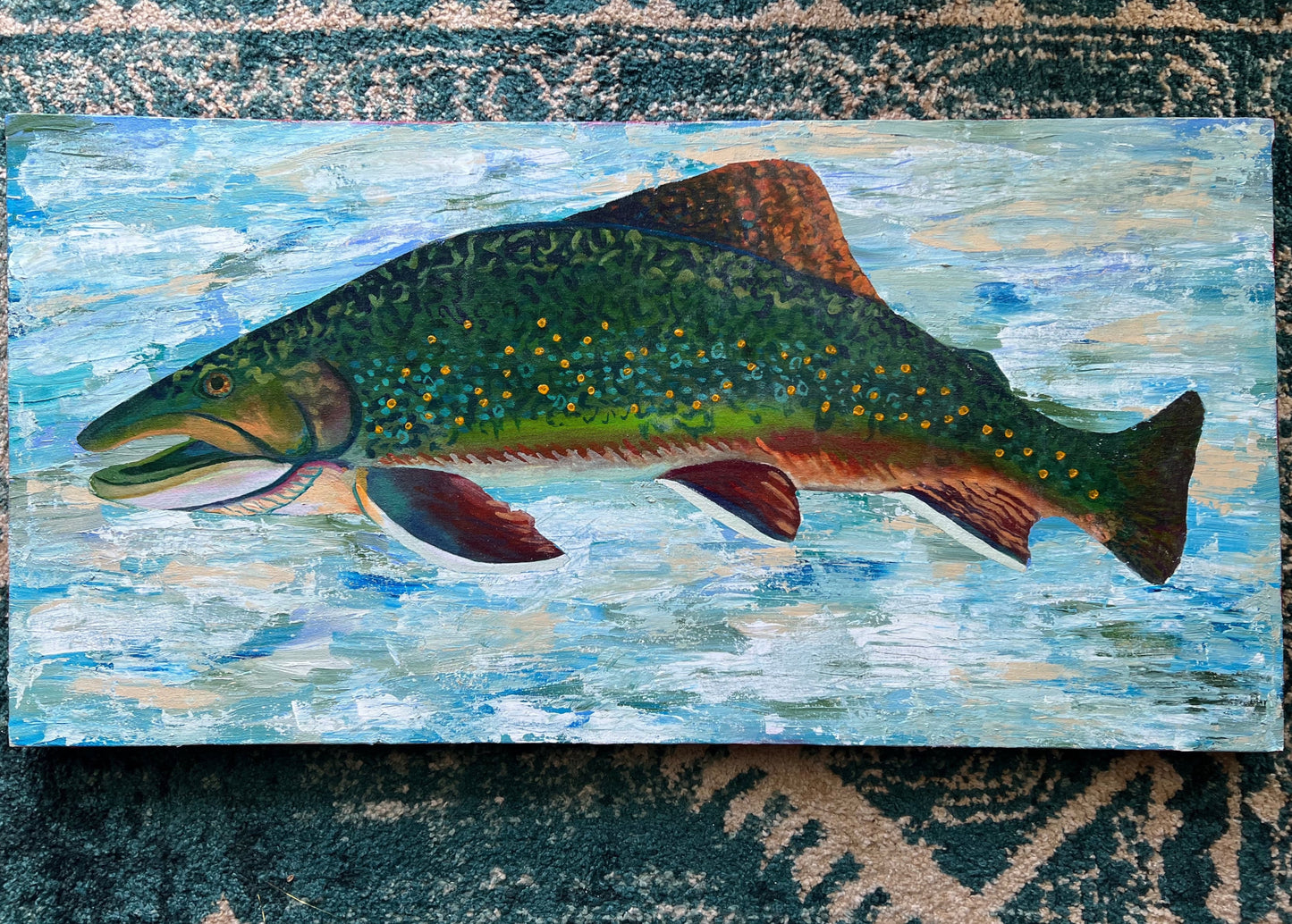 
                  
                    Art Bio: The Brook Trout. This work combines textures and techniques of acrylic painting to create a trout enveloped in an abstracted water space. The use of glazing creates a glow within the colors of the brook trout. All together the colors and techniques in this piece display the natural beauty of the brook trout.
                  
                