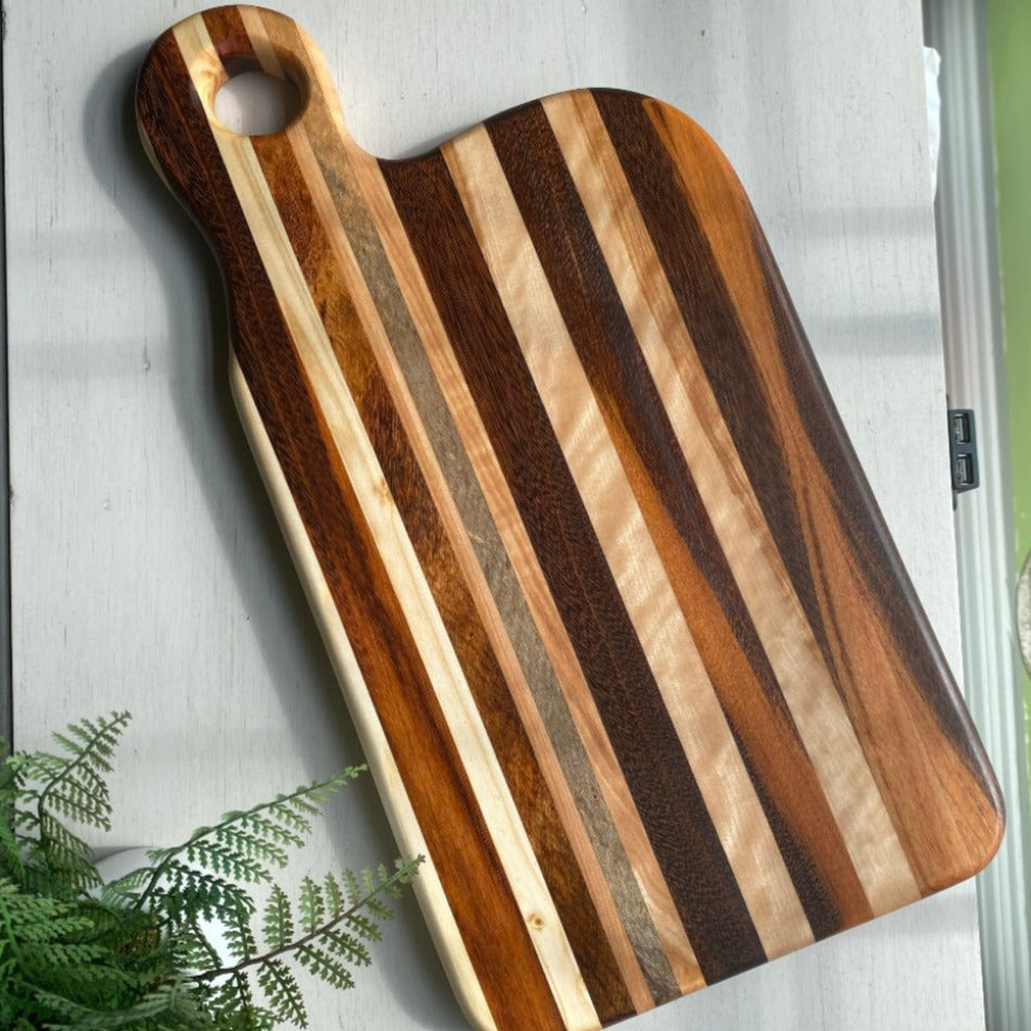 
                  
                    Composed of Tiger Heart, Goncalo Alves and Black Limba, the 19" long, 10" wide, Handcrafted Charcuterie Board is a stunning 1" thick spectacle of contrast and color.
                  
                