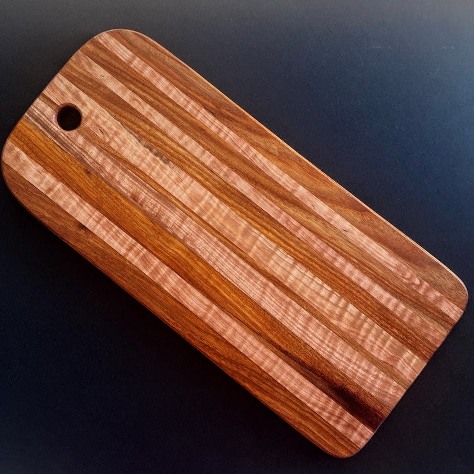 
                  
                    The Handcrafted Charcuterie Board or Bread Board is crafted from Tiger Maple and Canary Wood, measuring 18 x 8 x 1. This combination of woods offers remarkable depth. It is then seasoned with Milie's Tung Oil.
                  
                