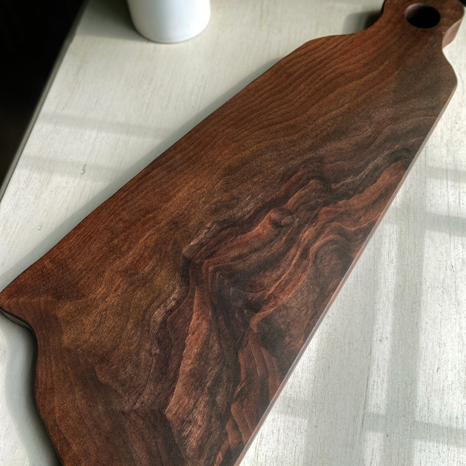 
                  
                    This 22"x10"x1" Charcuterie Board is crafted from Claro Walnut Live Edge and finished with Sutherland Welles Tung Oil. It makes an ideal centerpiece for any table.
                  
                