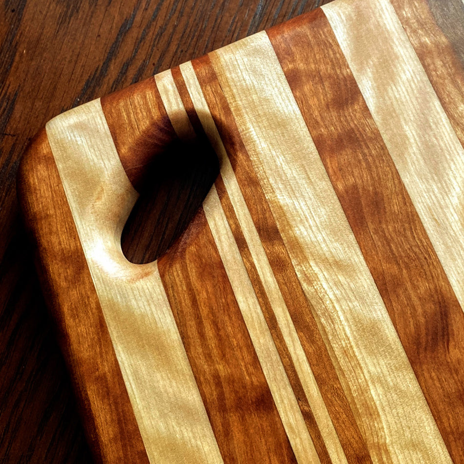 
                      
                        This Charcuterie Board is crafted from Curly Cherry and Tiger Heart. These two wood species are beautiful together. cutting surface. The 17 3/4-inch board delivers ample space to hold meats, cheeses, fruits, and other appetizers, while the 1-inch thickness offers durable rigidity. A Millie's All-Purpose Penetrating Tung Oil finish seals to further reinforce the board's strength and longevity.
                      
                    