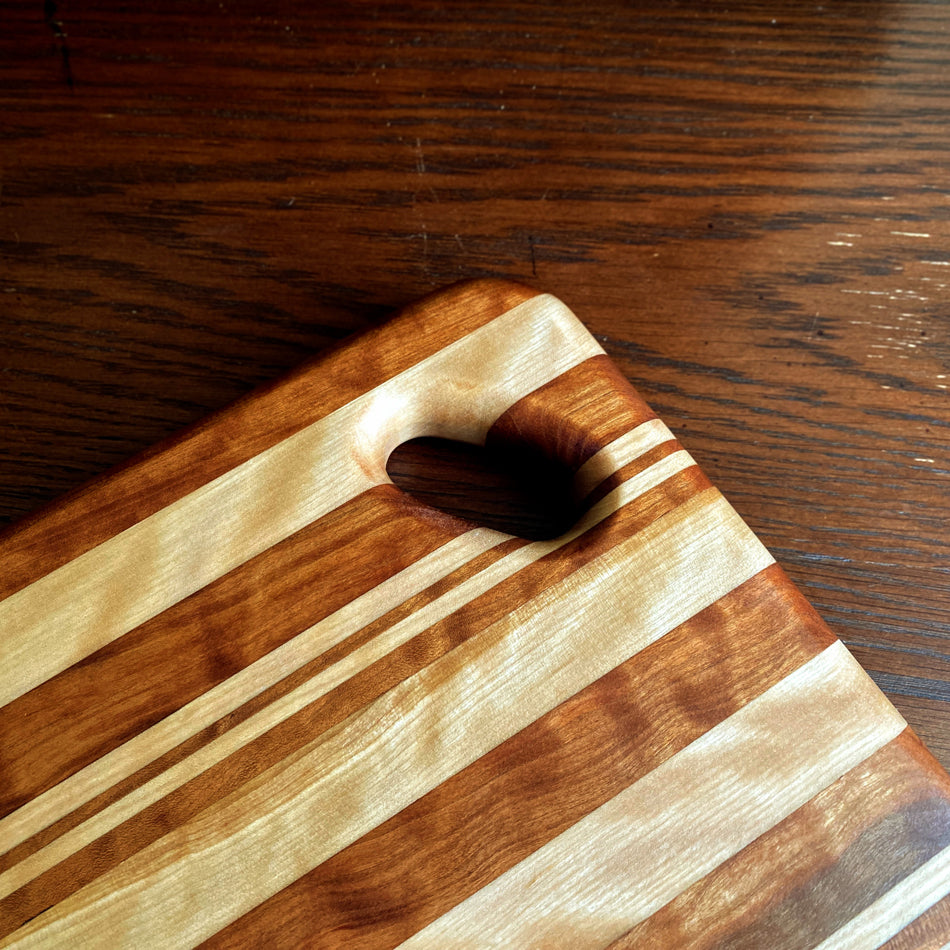 
                  
                    This Charcuterie Board is crafted from Curly Cherry and Tiger Heart. These two wood species are beautiful together. cutting surface. The 17 3/4-inch board delivers ample space to hold meats, cheeses, fruits, and other appetizers, while the 1-inch thickness offers durable rigidity. A Millie's All-Purpose Penetrating Tung Oil finish seals to further reinforce the board's strength and longevity.
                  
                