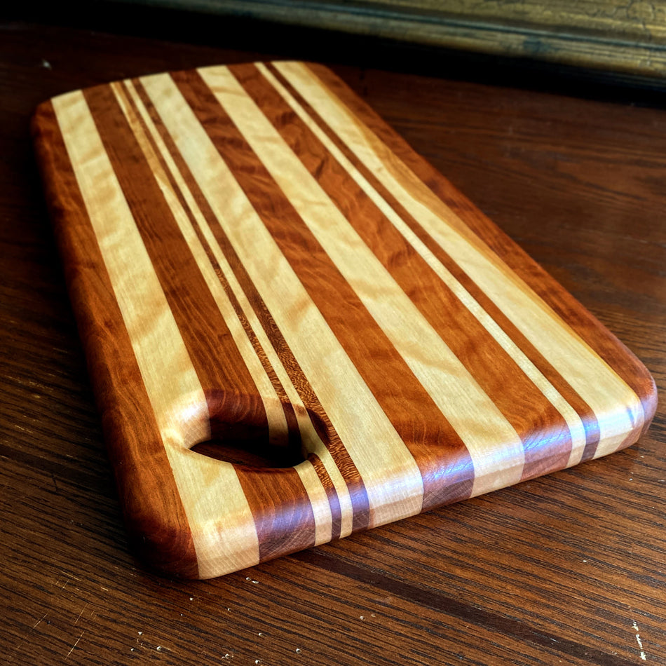 This Charcuterie Board is crafted from Curly Cherry and Tiger Heart. These two wood species are beautiful together. cutting surface. The 17 3/4-inch board delivers ample space to hold meats, cheeses, fruits, and other appetizers, while the 1-inch thickness offers durable rigidity. A Millie's All-Purpose Penetrating Tung Oil finish seals to further reinforce the board's strength and longevity.