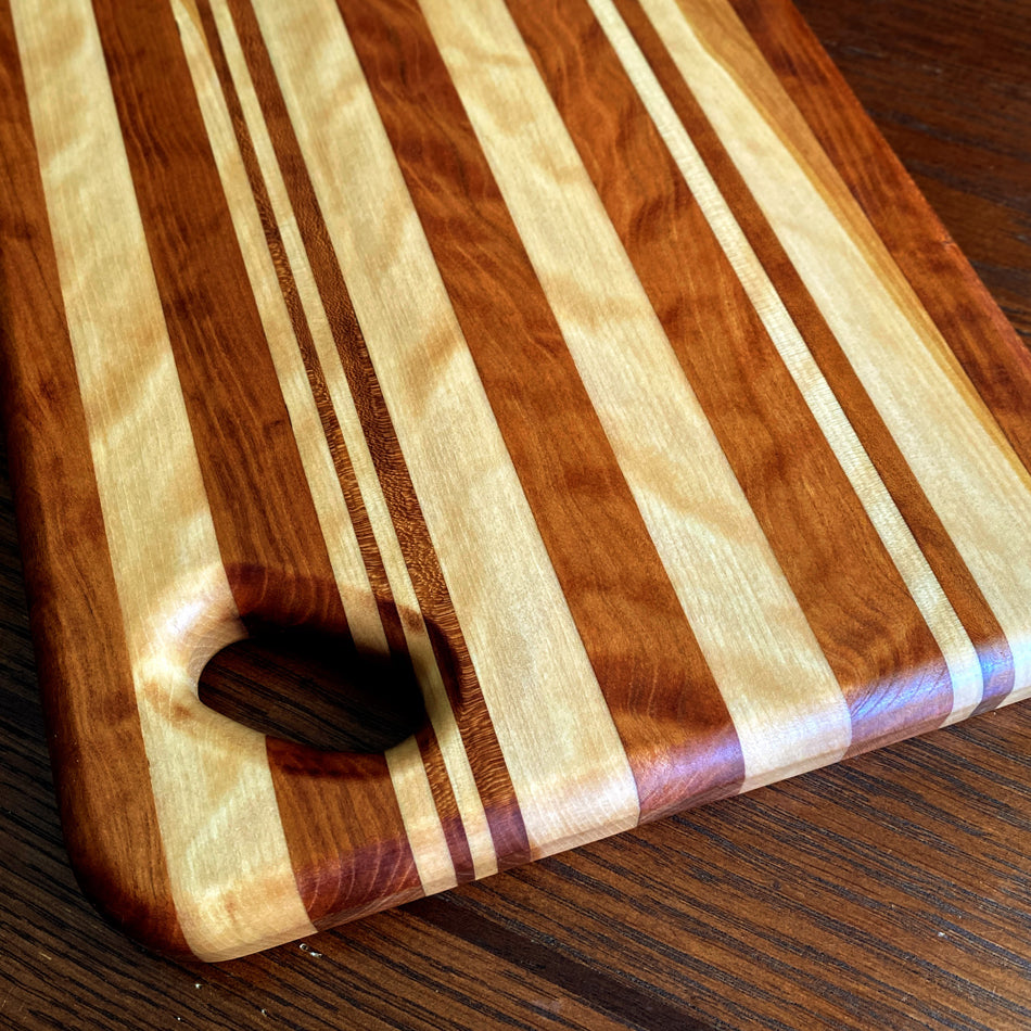 
                      
                        This Charcuterie Board is crafted from Curly Cherry and Tiger Heart. These two wood species are beautiful together. cutting surface. The 17 3/4-inch board delivers ample space to hold meats, cheeses, fruits, and other appetizers, while the 1-inch thickness offers durable rigidity. A Millie's All-Purpose Penetrating Tung Oil finish seals to further reinforce the board's strength and longevity.
                      
                    