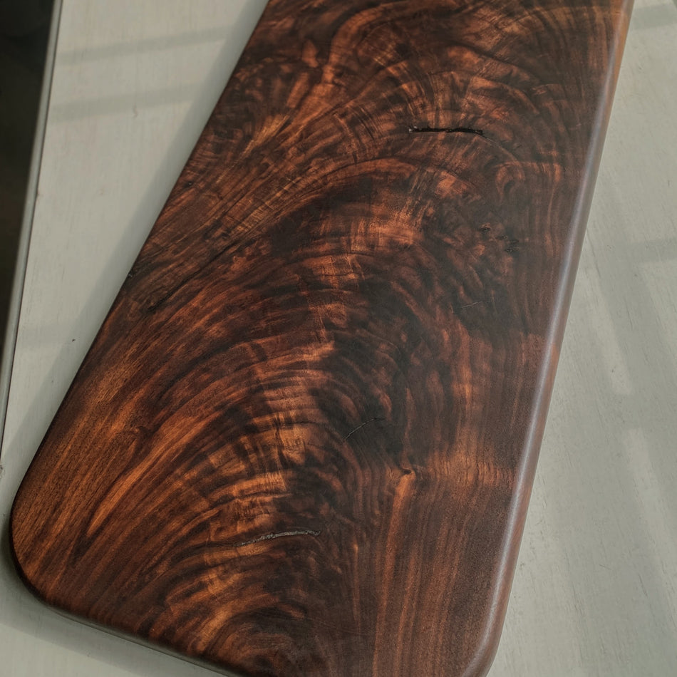 
                      
                        This Handcrafted Charcuterie Board is fashioned from Highly Figured Walnut wood from the Northeastern States. Its generously sized design, measuring 22" Long, 9" wide, and " thick, and weighing nearly 15 pounds, creates an impressive centerpiece for any gathering.
                      
                    