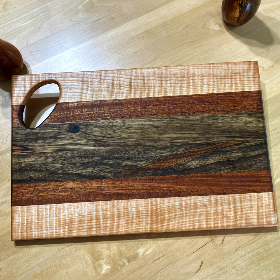 Observe the exquisite combination of Black Limba, Jatoba and Curly Birch, a marriage of wood hues and textures. Gaze at the golden-brown of the Black Limba that pairs so perfectly with the similar shade of the Jatoba. The Black Limba strips were cut and arranged with intention to pair with the Jatoba.
