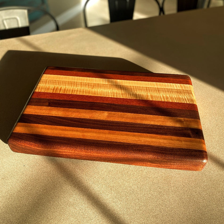 
                  
                    Create a refined atmosphere at every gathering with this exquisite piece. Edge Grain Serving Board is 17 3/4" L, 12" W and 1 3/4" T. It's crafted with Leopard Wood, Padauk, Tiger Maple and Walnut.
                  
                