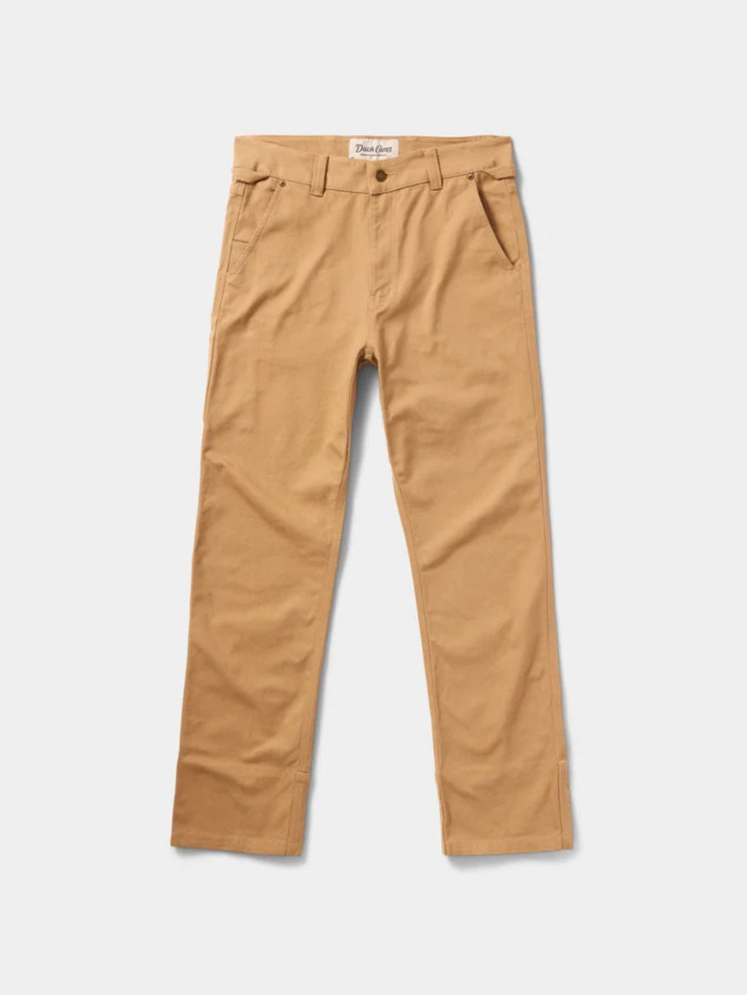A pair of tan chino pants laid flat against a light gray background. The brand label 'The Denim Company' is visible on the inner waistband.