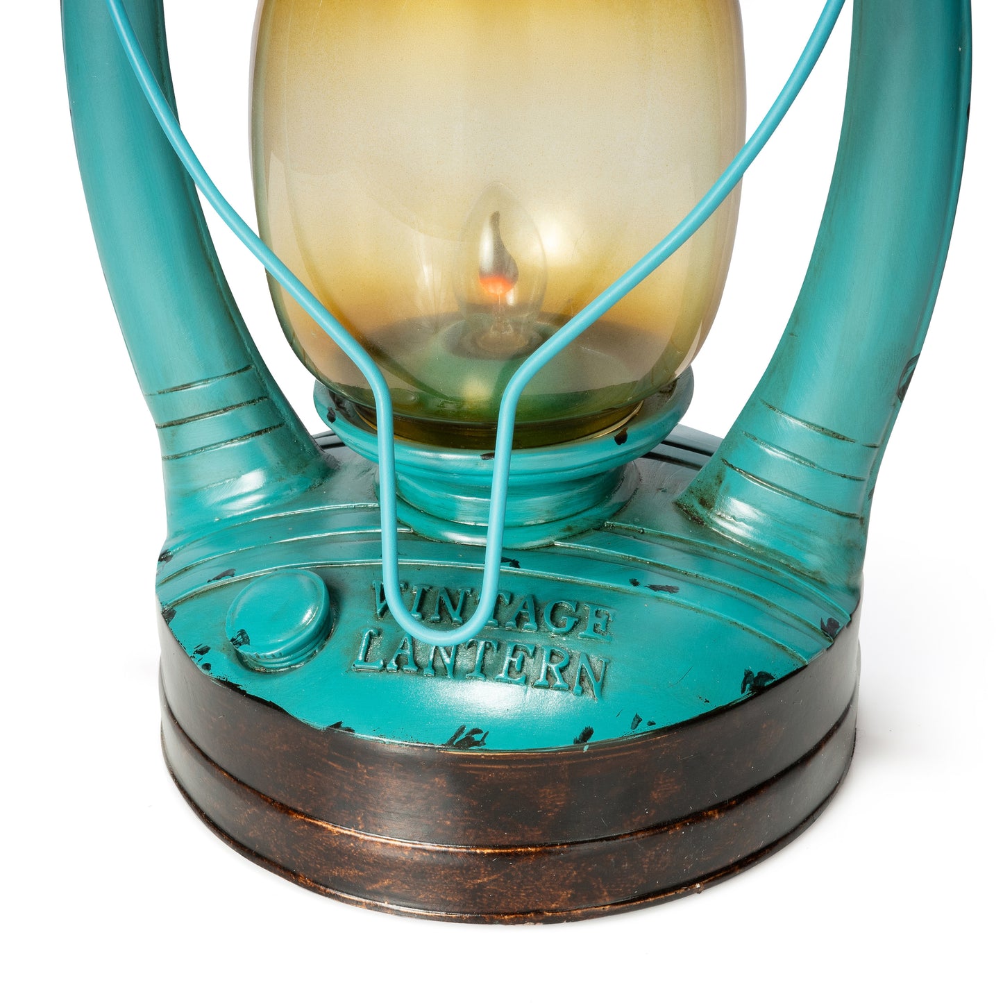 Close-up of a vintage-style lantern with a turquoise painted metal body, a warm amber-tinted glass chamber, and a dark brown distressed base. The words 'VINTAGE LANTERN' are embossed on the front.