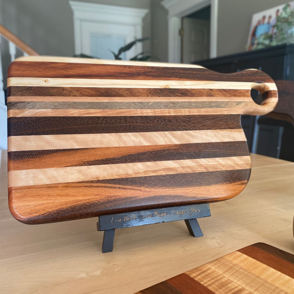 
                  
                    Composed of Tiger Heart, Goncalo Alves and Black Limba, the 19" long, 10" wide, Handcrafted Charcuterie Board is a stunning 1" thick spectacle of contrast and color.
                  
                