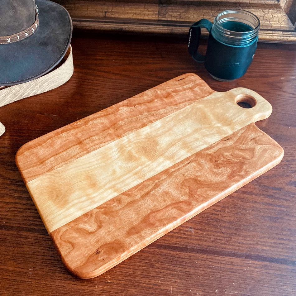 
                  
                    Measuring 18" in length and 13 1/4" in width at a depth of 1", this Charcuterie Board is meticulously handcrafted from Curly Cherry and Curly Birch and finished with Sutherland Welles Ltd.® Botanical Polymerized Tung Oil High Lustre and Bowl & Board™.
                  
                