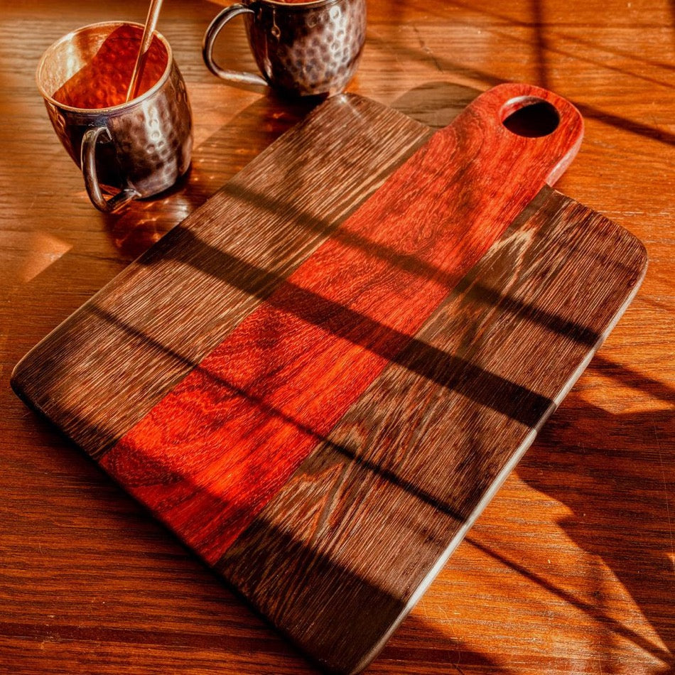 
                  
                    This Charcuterie Board is crafted from Padauk and Wenge for a beautiful yet durable cutting surface. The 16-inch board (including handle) delivers ample space to hold meats, cheeses, fruits, and other appetizers, while the 1-inch thickness offers durable rigidity. A Millie's All-Purpose Penetrating Tung Oil finish seals to further reinforce the board's strength and longevity.
                  
                